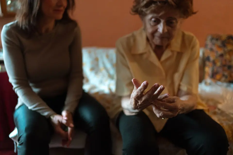 Carer chatting with an elderly woman at home